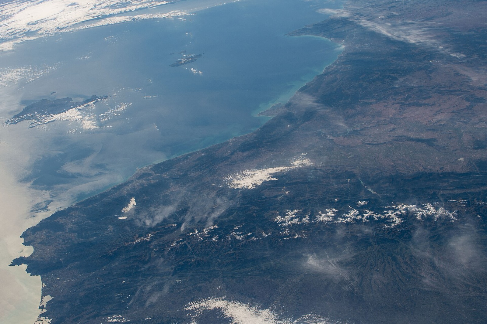 La costa catalana i els Pirineus nevats vistos en obliqua des de l'Estació Espacial Internacional, amb les Illes Balears mar endins