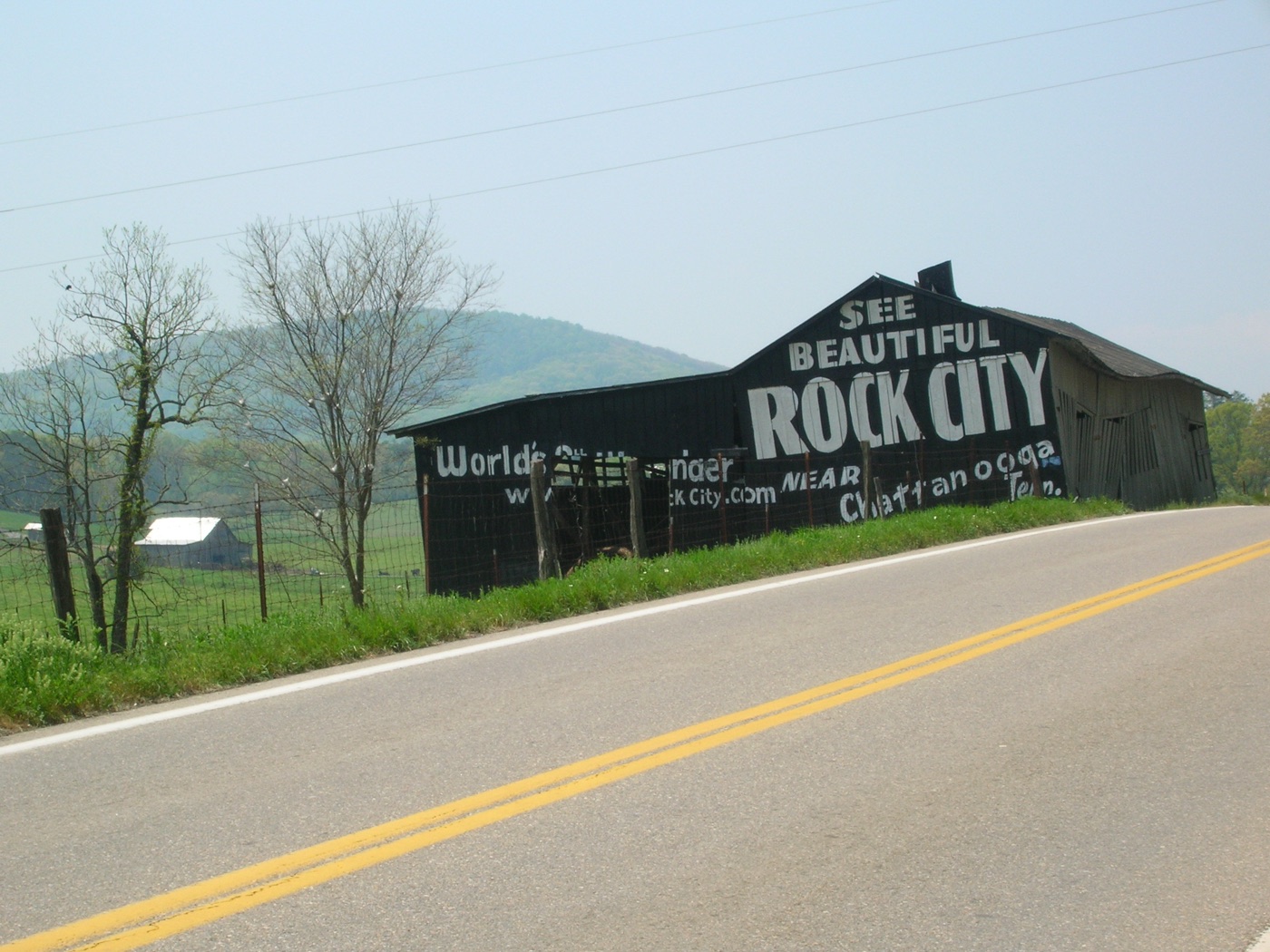 Un granero con "SEE ROCK CITY" pintado en grandes letras blancas sobre el tejado negro, parte de la campaña publicitaria de carretera de principios del siglo XX